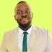 Portrait of a smiling man in a beige suit and green tie against a bright lime background.